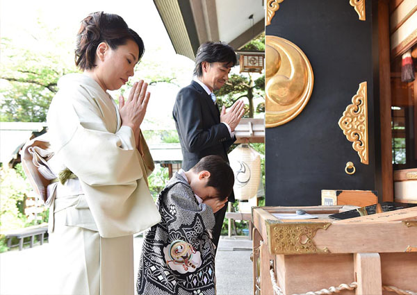着物を着た家族が神社で祈祷している