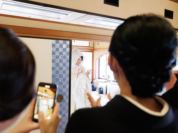 会場の襖が開き、ゲストの拍手に包まれて入場する、綿帽子姿の白無垢の花嫁。