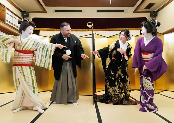 金屏風の前で浅草芸者とゲームを楽しむ新郎新婦