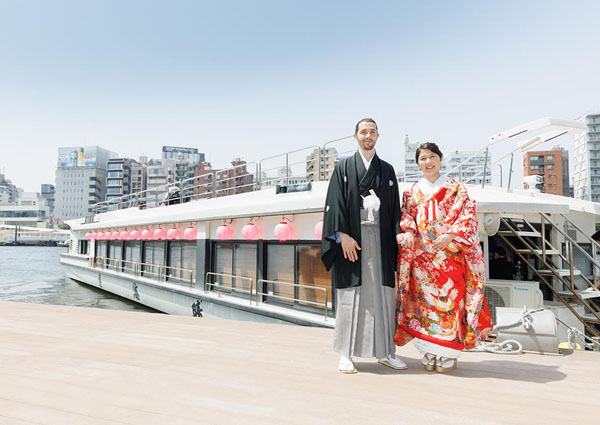 赤い提灯が連なる屋形船「晴海屋」の前に立つ色打掛の新婦と新郎