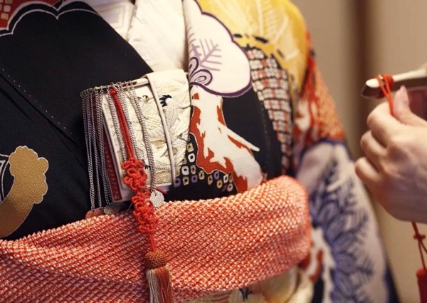 黒地の着物に赤い帯揚げを締め、銀の房飾りが下がる箱せこを胸元に挿した花嫁和装のアップ